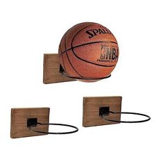 two basketballs are mounted on wooden hooks