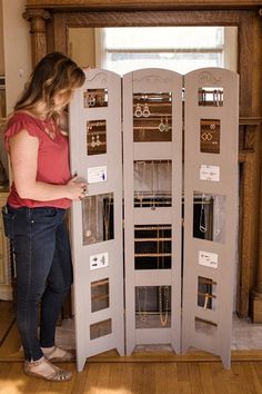 a woman standing in front of a display case with jewelry on it's sides