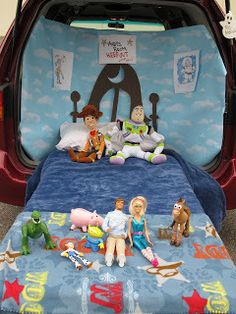 the back of a car with toy figures in it's trunk and bed area