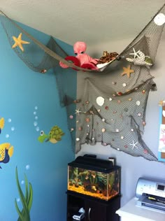 a fish net hanging from the ceiling above a fish tank in a child's room