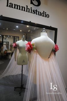 two mannequins dressed in white with pink flowers on their heads and veil