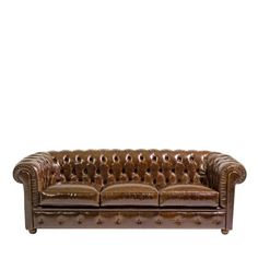 a brown leather couch sitting on top of a white floor next to a wooden frame