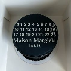 a black and white cake in a box with the name maison margiela paris on it