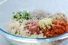 a glass bowl filled with rice, meat and seasoning next to an orange pepper