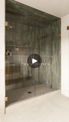 a bathroom with a glass shower door and tiled walls