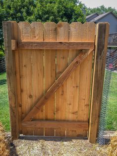 a wooden gate in the middle of a yard