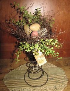 a bird's nest filled with eggs and greenery on a round table mat