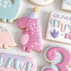 some decorated cookies are on a table with other decorations and cookie items in the shape of animals