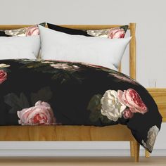 a bed covered in black and pink flowers