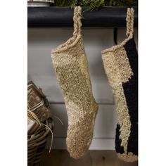 two knitted stockings hanging from a mantle