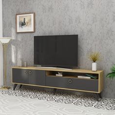 an entertainment center with a flat screen tv on it's stand in front of a wallpapered wall