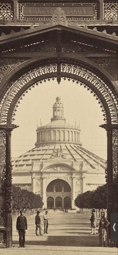 an old black and white photo of people in front of a large building with arches