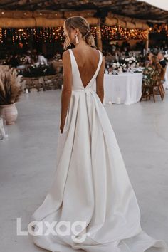 a woman in a white wedding dress looking down at the ground