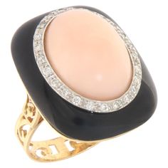 This exquisite ring embodies a luxurious fusion of exquisite design and craftsmanship, masterfully crafted in 18 karat white and yellow gold. It stands as a stunning example of how precious materials can be combined to create a piece of jewelry that instantly draws attention and celebrates the beauty of nature and artisan skill. At the heart of the ring sits a charming pink coral, known for its gentle and soothing shades, symbolizing protection and eternal love. This central gem is expertly set Yellow Gold Cocktail Ring, Fancy Jewellery Designs, Gold Cocktail, Gold Cocktail Ring, Fancy Jewellery, Precious Gems, Sparkle Diamonds, Cocktail Rings, Luxury Jewelry