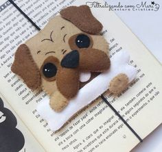 a close up of a book with a stuffed dog on it's cover and an open book in the background