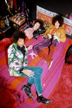 two young men sitting on top of a bed next to each other in front of a mirror