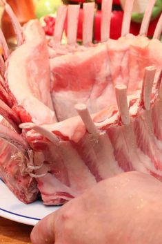 raw meat on a plate being cut into pieces