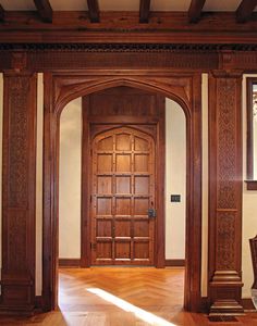 an empty room with wooden doors and wood flooring on either side of the doorway