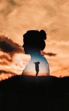 the silhouette of a woman with her hair in a bun is shown against a sunset