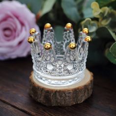 a glass crown sitting on top of a wooden piece