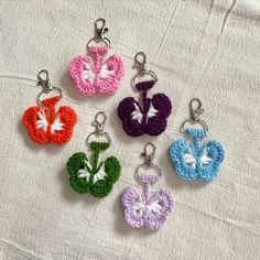 four crocheted key chains with flowers on them