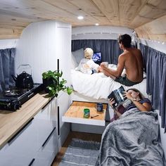 a man sitting on top of a bunk bed in a room filled with wooden floors