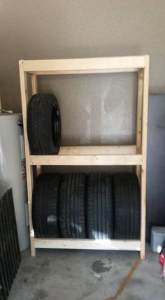 some tires are stacked on top of each other in a storage rack next to a water heater