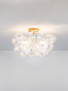 a chandelier with bubbles hanging from it's ceiling and the light is on