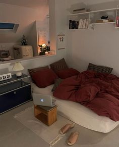 a bed sitting in the middle of a room next to a laptop computer