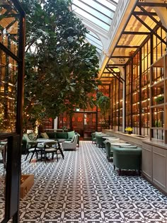 the inside of a restaurant with tables and couches in front of large windows on both sides