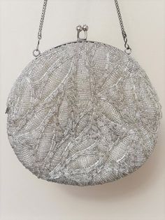 "Vintage Desiger Walborg round handbag The color is an iridescent silver seed beads covered the whole bag kiss lock closure round in shape silk type lining no missing or hanging beads the stitching inside by the edge of the lining has become undone. The outside of the bag is not ripped at all, just the inner lining has been pulled away as seen in the photos. see inside bag there is small minor mark but in very good condition no stains The bag is 6 1/2\" round snake chain measures 14\" beautiful Silver Beaded Evening Bag For Formal Occasions, Silver Sequined Wedding Clutch, Formal Silver Beaded Evening Bag, Silver Beaded Evening Bag For Events, Silver Beaded Clutch For Formal Occasions, Silver Beaded Evening Bag, Silver Beaded Glamorous Clutch, Formal Silver Beaded Clutch, Glamorous Silver Beaded Clutch