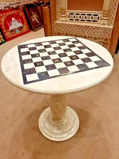 a chess board on top of a table in a room with chairs and rugs