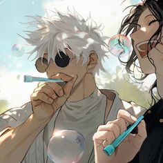 two people are blowing bubbles and one is holding a blue toothbrush in his mouth