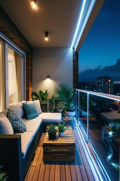 a balcony with couches and plants on it at night, lit up by lights