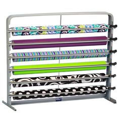 a rack that has many different colored fabrics on it and is holding several rolls of fabric