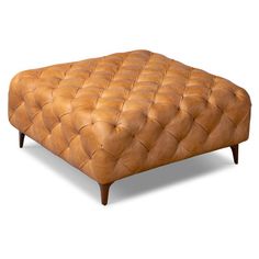 a tan leather ottoman with wooden legs and footrests on an isolated white background