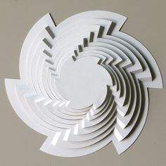 a circular cut out of white paper sitting on top of a table