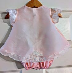 A perfect little ensemble for the newest family member, this tiny diaper shirt and bloomers were hand-made by me from an exquisite cotton organdy embroidered place mat.  The darling little top closes with authentic mother-of-pearl buttons and is lined with 100% cotton lawn.  Sized at 0-3 months, this is a great gift for your best friends who are becoming first-time parents or grandparents. Cotton Sets With Lace Trim And Short Sleeves, Cotton Lace Trim Sets With Short Sleeves, Cotton Short Sleeve Sets With Lace Trim, Spring Pink Embroidered Sets, Cotton Embroidered Sets For Baptism, Embroidered Summer Nightgown, Embroidered Newborn Outfit, Embroidered Cotton Sets For Baptism, Embroidered Toddler Dress