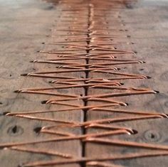 a wooden table topped with lots of metal rods on top of it's sides