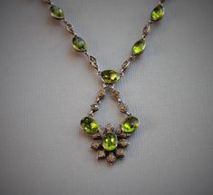 "Entrancing and very rare Georgian necklace, circa 1800 Peridot green foiled paste jewels accented with diamond paste spacers. The green paste stones glow in the light. Rivieres with drops like this are incredibly difficult to find! Measurements\" Necklace - 19\" with an additional 1 3/4\" for the drop Each green paste - 1/2\" with loops Light wear, fitting for age. No damage or repairs to note. Please note, insurance is not included in the postage cost. Please contact me for a quote if interest Green Peridot Necklace In Fine Jewelry Style, Formal Green Stone Necklace, Formal Green Stone Necklaces, Antique Green Jeweled Necklace, Antique Green Jeweled Necklaces, Vintage Green Jewelry With Rose Cut Diamonds, Vintage Green Diamond Jewelry, Green Jeweled Formal Jewelry, Formal Peridot Pendant Necklace