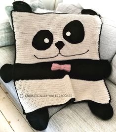 a panda bear crocheted blanket sitting on top of a couch