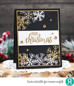 a black and white christmas card with gold foil snowflakes