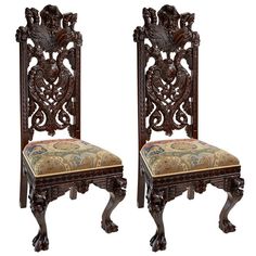 a pair of carved wooden chairs with floral upholstered back and seat cushions, side by side