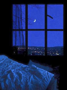 a bed sitting under a window next to a night sky