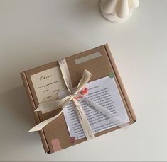 an open book with ribbon tied around it on a table next to a candle holder