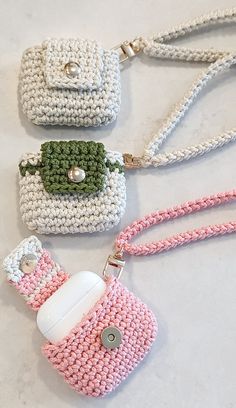 three crocheted purses sitting on top of a white table next to each other