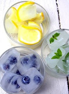 three plastic bowls filled with ice and lemon slices on top of a white wooden table