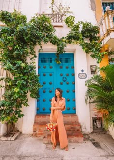 a woman standing in front of a blue door