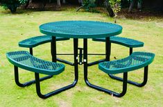 a green table and four benches in the grass