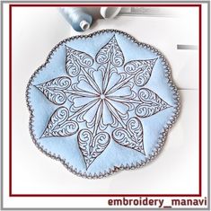 a blue and white circular piece of cloth with an intricate design on the center, surrounded by thread